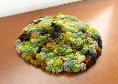 a shot of a pillow made of pom poms made to look like moss