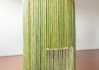 a 2m bamboo art installation made into a round shelter with a front opening of thin yellow wool people can climb into